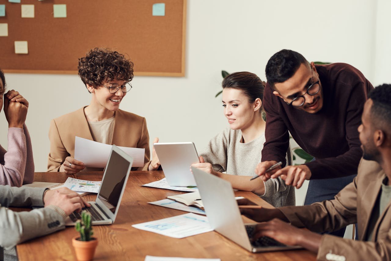 A diverse group of professionals engaged in a collaborative office meeting, sharing ideas and discussing projects.